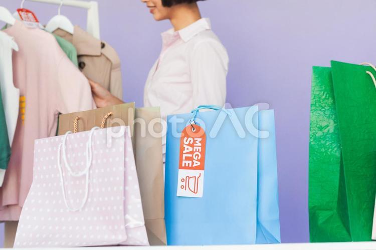 セールの服を見ている女性と紙袋 セール,ショップ,女性の写真素材