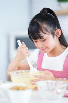 キッチンでお菓子作りを頑張る少女 女の子,小学生,日本人の写真素材