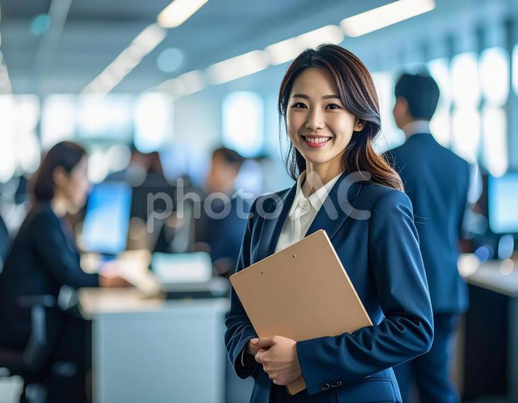 オフィスでPCを持って微笑む女性社員 オフィス,ビジネス,社員の写真素材