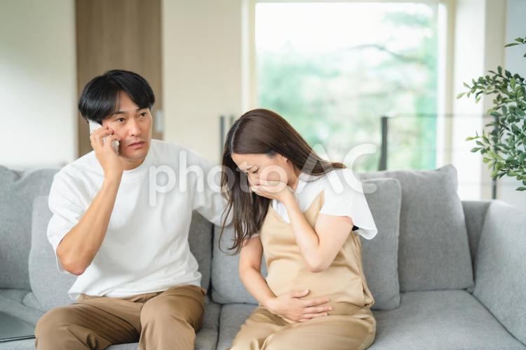出産直前の妊婦の病院を探す男性（スマホ） 破水,陣痛,妊婦の写真素材