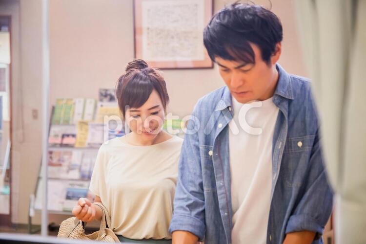 受付で何か書き込む男女 受付,チェックイン,カウンターの写真素材