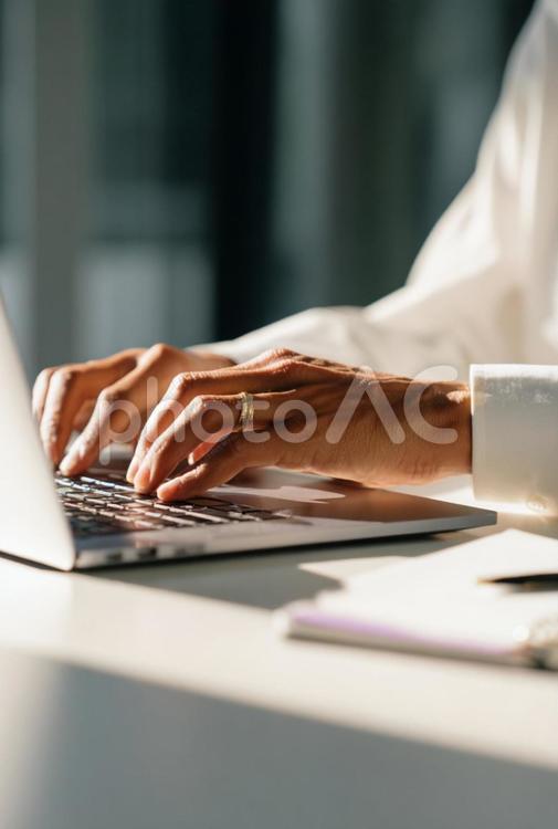 光が差し込む部屋でのビジネスワーク風景 タイピング,ノートパソコン,手元の写真素材