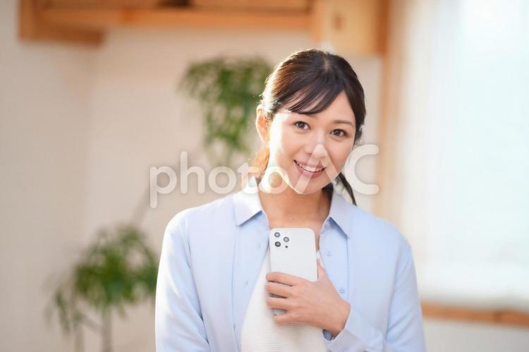 携帯を持ってカメラ目線の女性 女性,主婦,携帯の写真素材