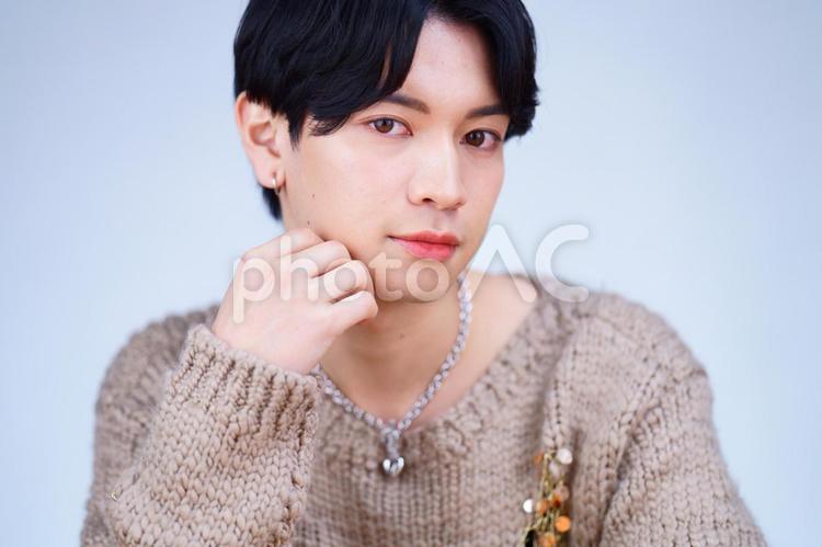 頬杖をするニットの日本人男性 男性,頬杖,ポーズの写真素材