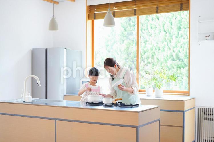 鍋の蓋を取り中を見る親子 母,娘,女の子の写真素材