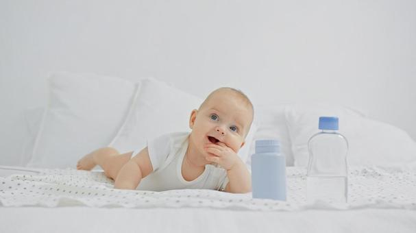 左指を口に入れ見上げる赤ちゃん 左指を口に入れ見上げる赤ちゃんの写真