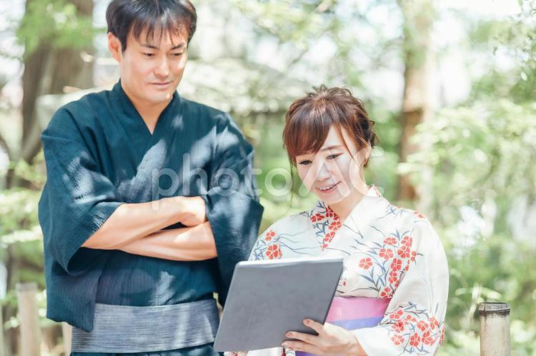 タブレットを使う浴衣姿の男女 浴衣,タブレット,タブレットpcの写真素材
