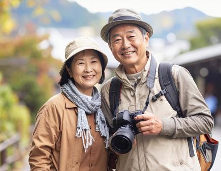 カメラを持って旅する仲良しシニア夫婦の写真