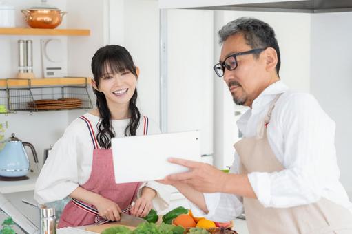 キッチンで料理を作るミドルの夫婦 キッチンで料理を作るミドルの夫婦 料理,夫婦,家族の写真素材
