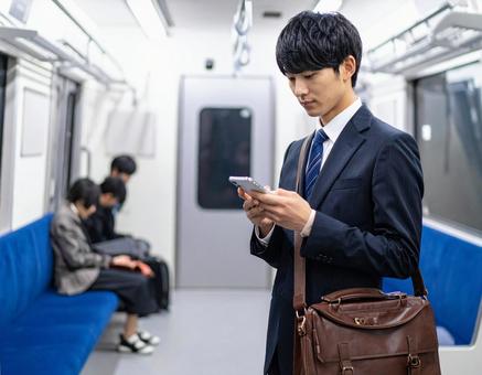 ビジネスシーン・地下鉄出張、スマホを見る ビジネスシーン・地下鉄出張、スマホを見るの写真