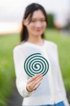 女性の持つ蚊取り線香のアップ 蚊取り線香,持つ,手元の写真素材