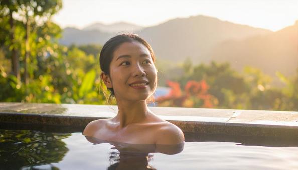 温泉につかってリラックスする若い女性 温泉につかってリラックスする若い女性の写真