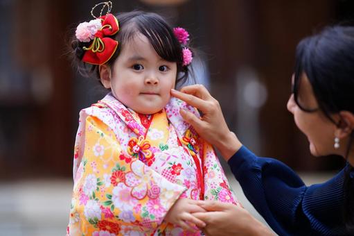 着物姿の女の子の頬に触れる母親の優しい手 七五三,お参り,七五三参りの写真素材