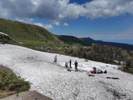 八幡平で残雪で滑る人たち 山,登山,八幡平の写真素材