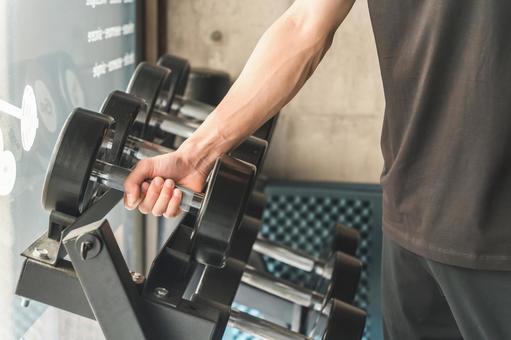 ダンベルで腕を鍛える筋トレをする男性 スポーツジム,筋トレ,ダンベルの写真素材