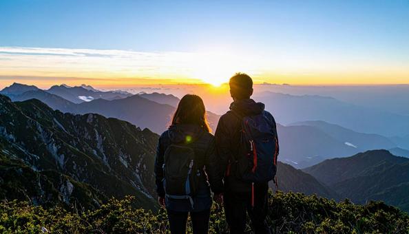 山から朝日を眺める日本人カップル 山から朝日を眺める日本人カップルの写真