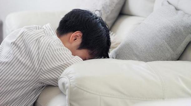 ソファで落ち込むアジア人男性 ソファで落ち込むアジア人男性 男性,落ち込む,ショックの写真素材