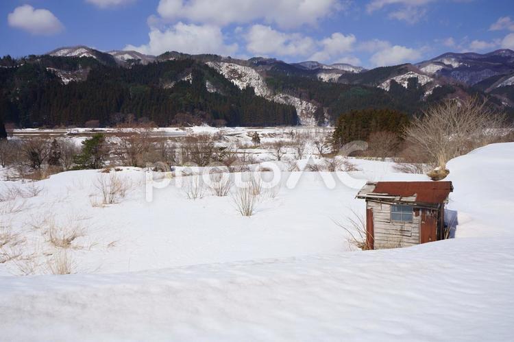 早春の雪が残る田んぼと小屋と白神山地の景色（秋田県八峰町）１ 早春,雪,残雪の写真素材
