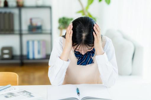 自宅で勉強中に悩む女子高生 自宅で勉強中に悩む女子高生の写真