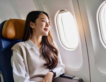 飛行機から外を見つめる女性 飛行機から外を見つめる女性の写真