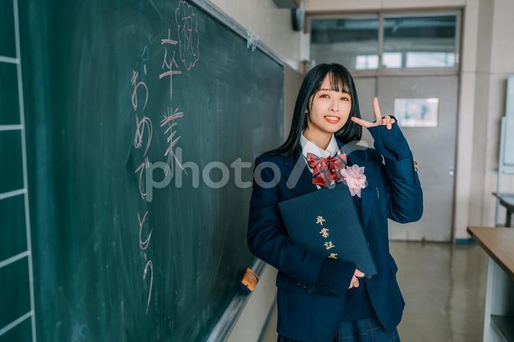 卒業式でピースをする女子高校生（右寄り） 女性,女子高,高校生の写真素材