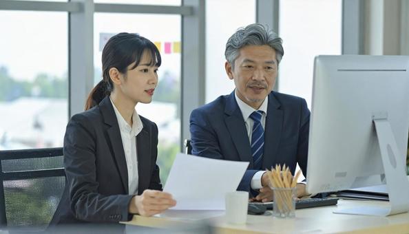 上司にデータを説明する女性社員 上司にデータを説明する女性社員の写真
