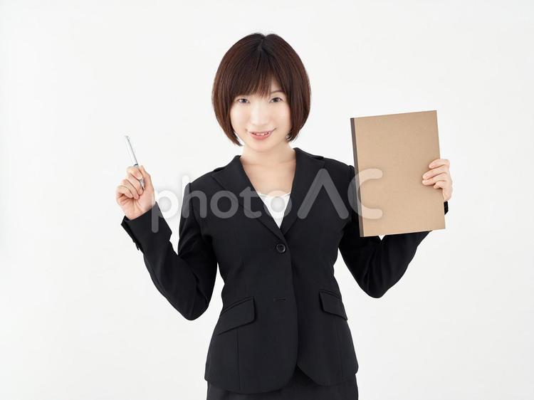 白い背景でペンとノートを用意する女性OL 女性,ol,ポーズの写真素材