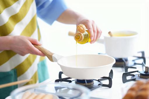 鍋とフライパンを持つ手の写真