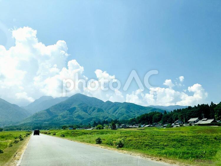山に囲まれた田舎ののどかな道をドライブ 田舎,風景,自然の写真素材