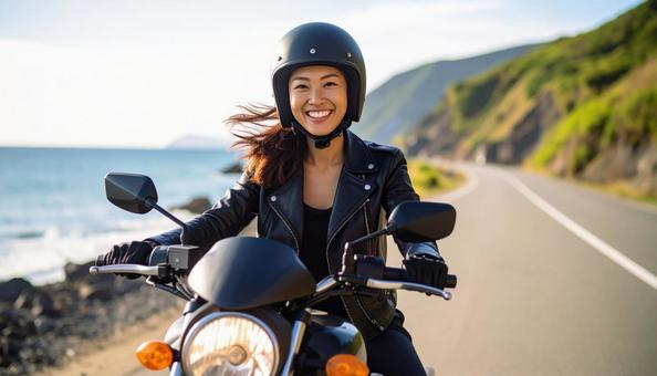 大きなバイクを運転して笑顔の女性の写真