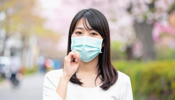 マスクをして辛そうにしている日本人女性 マスクをして辛そうにしている日本人女性の写真