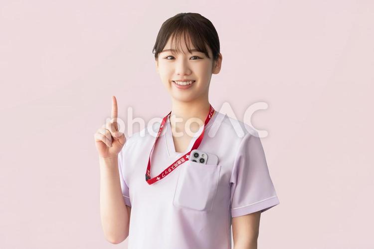 人差し指を立てて案内する女性医療スタッフ 女性,医療,医療スタッフの写真素材