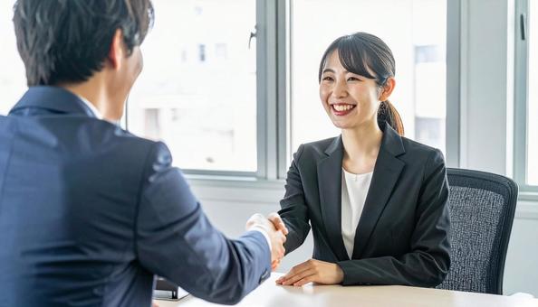 握手するビジネスパーソン 握手するビジネスパーソンの写真