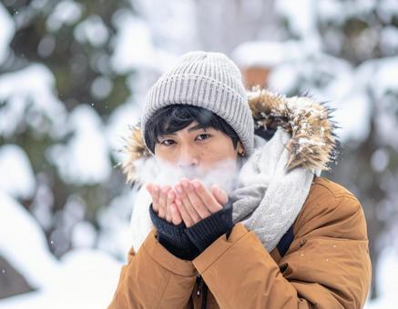 冬に手に息を吹きかける男性 冬に手に息を吹きかける男性の写真
