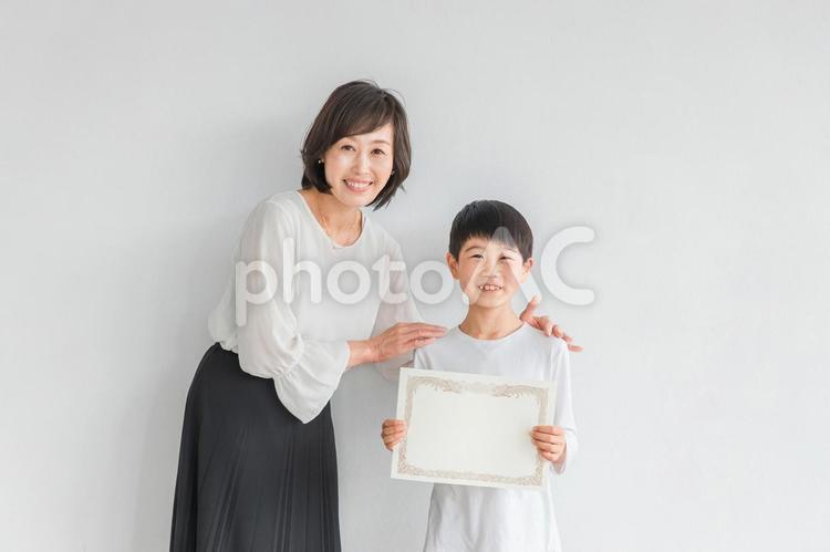 賞状を持つ笑顔の男の子と日本人女性 小学生,賞状,笑顔の写真素材