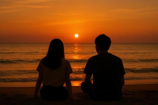 夕焼けの海を見る二人 夕焼けの海を見る二人の写真