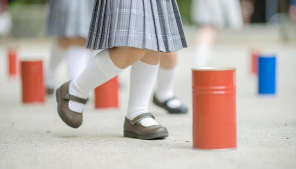 昔の遊び　缶蹴り遊びをする女の子の写真