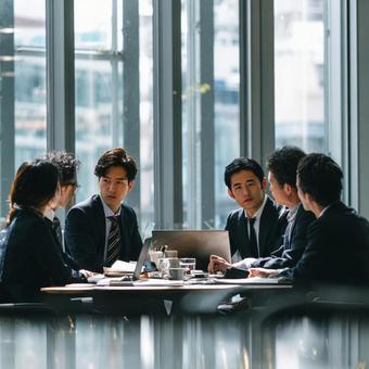 真剣な表情で話し合うビジネスパーソンたちの写真