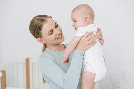 脇を持ち抱き上げ笑う女性 女性,赤ちゃん,かわいいの写真素材