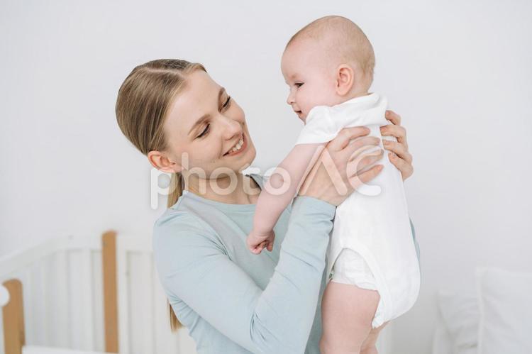 脇を持ち抱き上げ笑う女性 女性,赤ちゃん,かわいいの写真素材