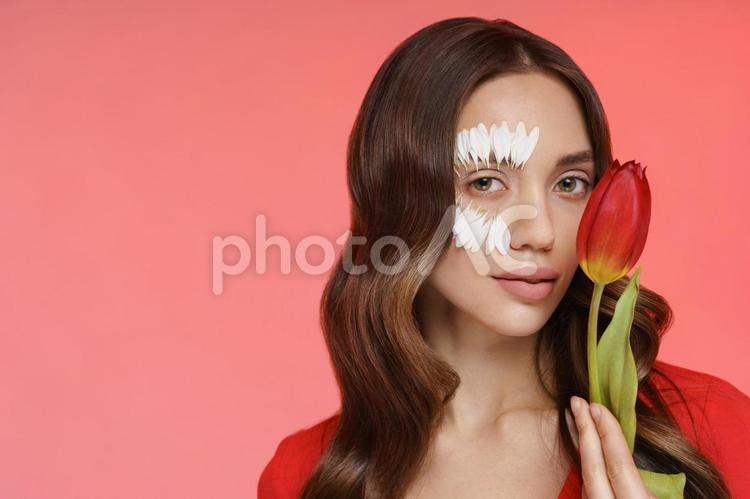 赤いチューリップを左手で持ちカメラ目線の女性 女性,チューリップ,持つの写真素材
