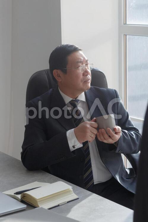 重役会議中飲み物を飲む男性1 会社員,男性,アジア人の写真素材