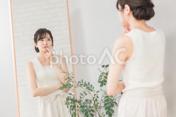 唇荒れ・口内炎に悩む鏡越しのアジア人女性 唇,唇荒れ,くちびるの写真素材