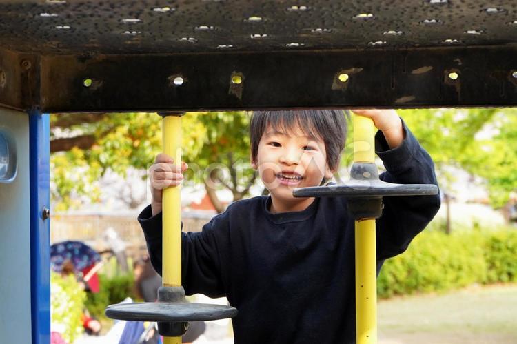 公園の遊具で遊ぶ笑顔の小学生の子供 子供,子ども,笑顔の写真素材