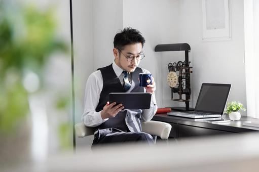 出勤前にくつろいでタブレットを見る男性 出勤前にくつろいでタブレットを見る男性 ビジネスマン,男性,人物の写真素材