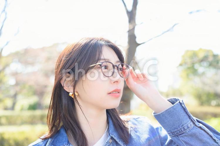 公園で遠くを見るメガネの女性 人物,女性,笑顔の写真素材