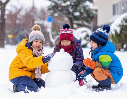 大雪で雪だるまを作る子供＃２の写真