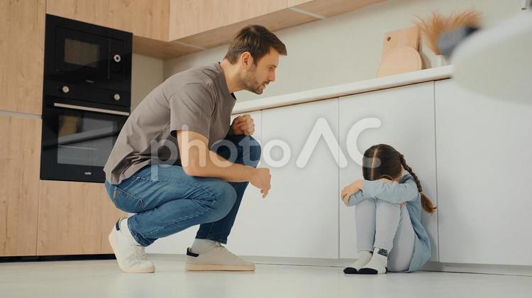 泣いている女の子に寄り添う男性 親子,男性,女の子の写真素材