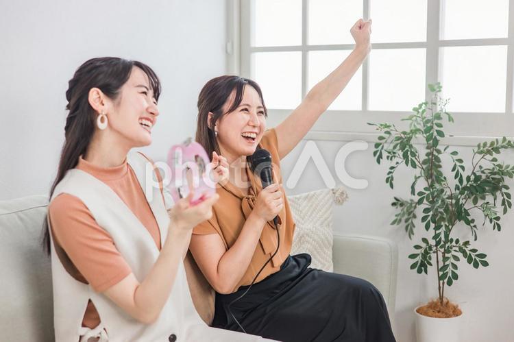 家でカラオケ・歌う若いアジア人女性 カラオケ,歌う,歌の写真素材
