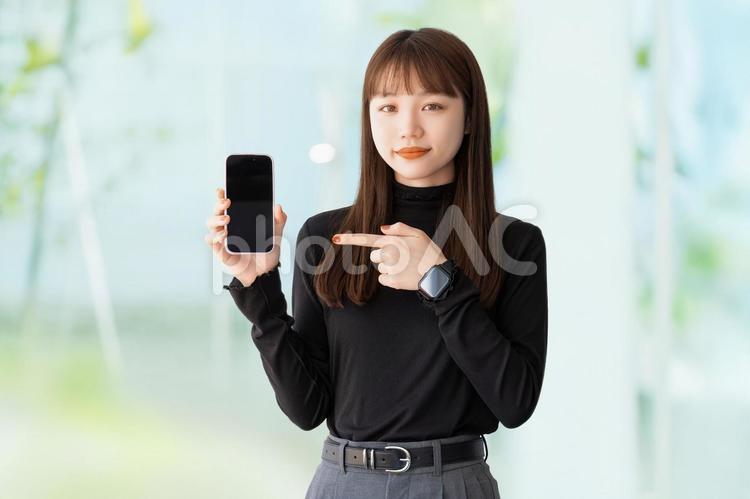 スマホを指差す女性・ビジネスウーマン 女性,スマホ,ビジネスの写真素材
